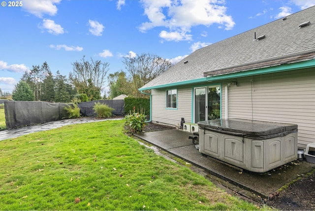view of yard with a patio area, a fenced backyard, and a hot tub