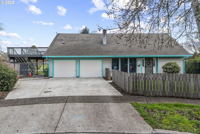 view of front of home featuring a garage, roof with shingles, and a fenced front yard