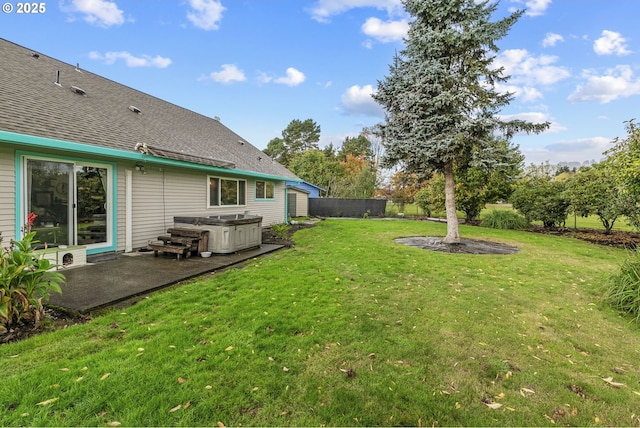 view of yard with a patio area, fence, and a hot tub