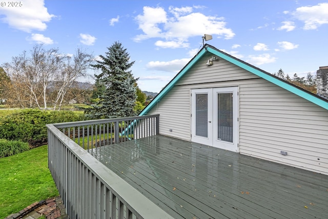 wooden deck featuring a yard and french doors
