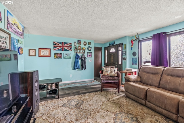 living room featuring a textured ceiling, wood finished floors, and baseboards