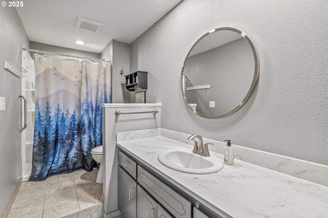 full bathroom with vanity, a textured wall, a shower with curtain, toilet, and visible vents