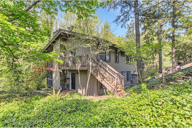 rear view of house featuring stairway and a deck