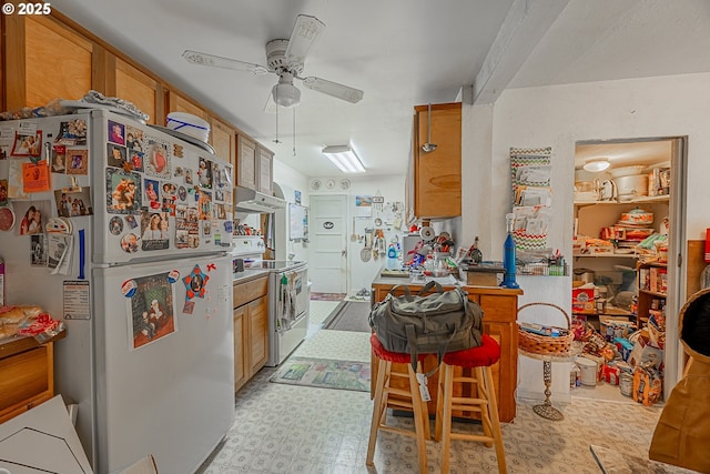 1446 N Collier St, Coquille, OR 97423 - kitchen with white appliances, ceiling fan, light flooring, and brown cabinetry