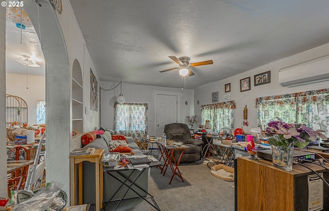 1446 N Collier St, Coquille, OR 97423 - carpeted living room featuring a wall mounted air conditioner, ceiling fan, healthy amount of natural light, and a textured ceiling