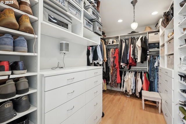 walk in closet with light hardwood / wood-style floors