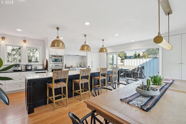 kitchen with white cabinetry, a center island, and decorative light fixtures