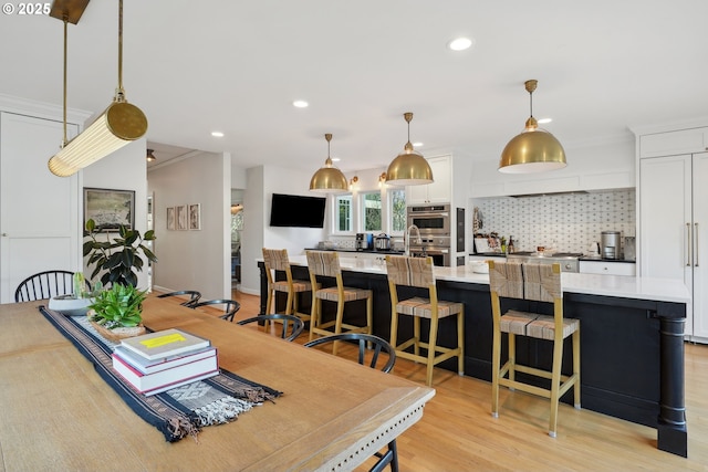 dining area with light hardwood / wood-style flooring and ornamental molding