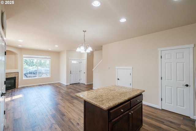 14146 Brittany Ter, Oregon City, OR 97045 - kitchen featuring dark brown cabinetry, a glass covered fireplace, dark wood-style flooring, decorative light fixtures, and a chandelier
