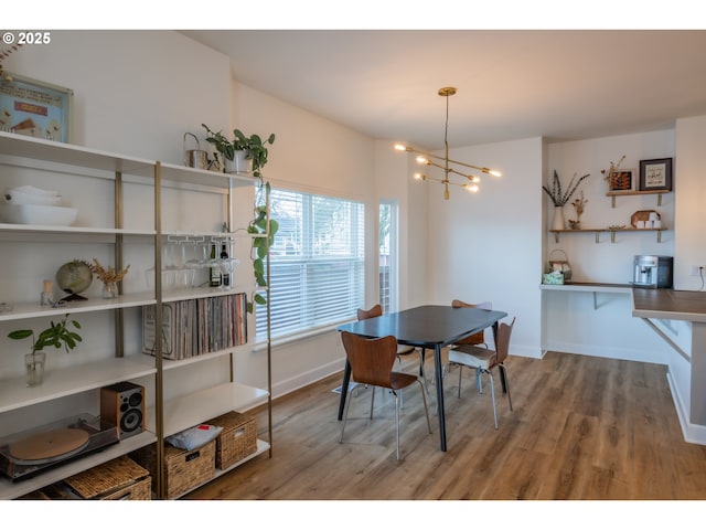 dining room featuring an inviting chandelier, wood finished floors, and baseboards