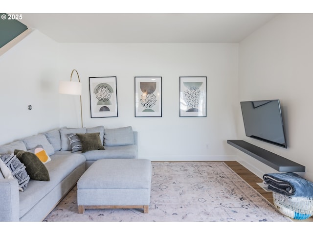 living area with light wood-type flooring and baseboards