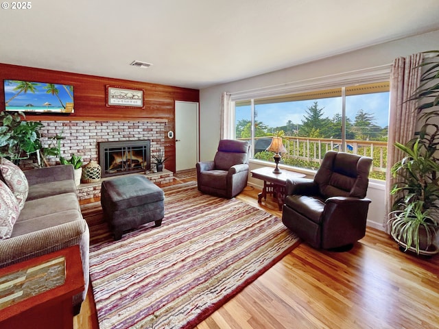 living room with visible vents, light wood-style floors, and a fireplace