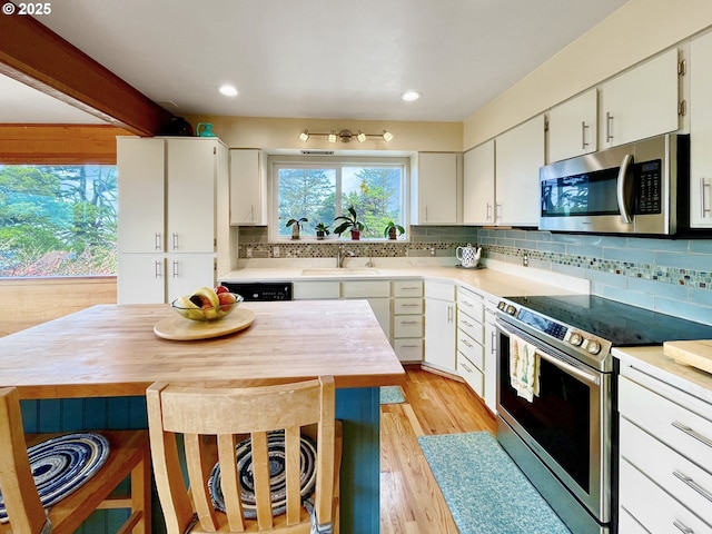 kitchen featuring backsplash, light countertops, a sink, and stainless steel appliances