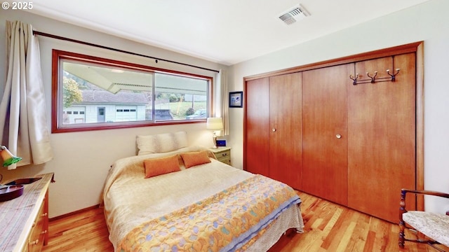 bedroom with visible vents, a closet, and light wood-type flooring