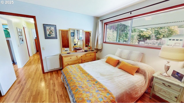 bedroom with light wood finished floors and radiator