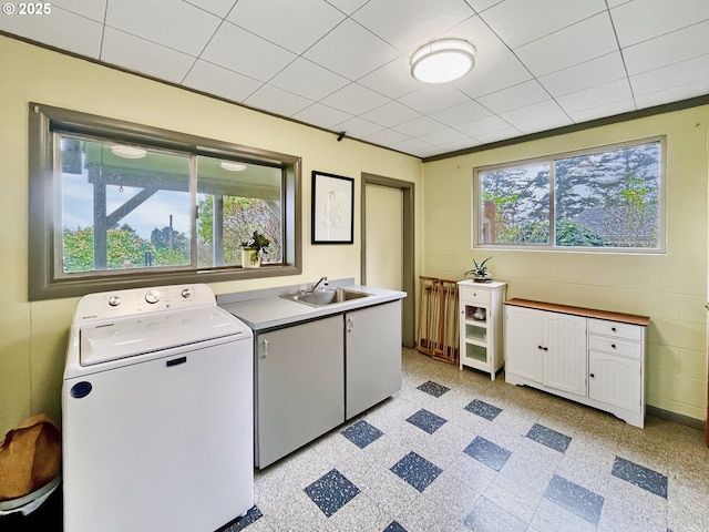 clothes washing area with cabinet space, washer / clothes dryer, a sink, and light floors