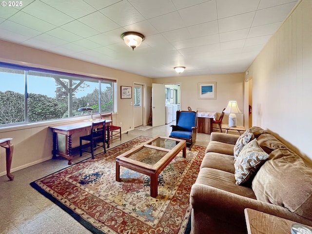 living room featuring washer / clothes dryer and baseboards