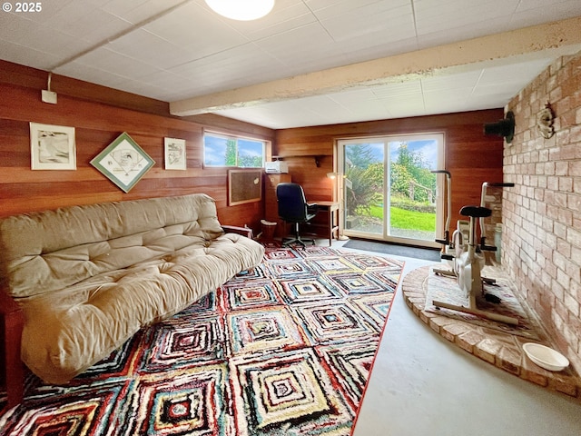 living area with wood walls and beam ceiling