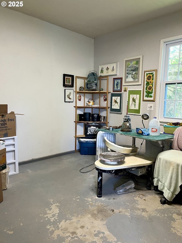 office with baseboards and concrete floors