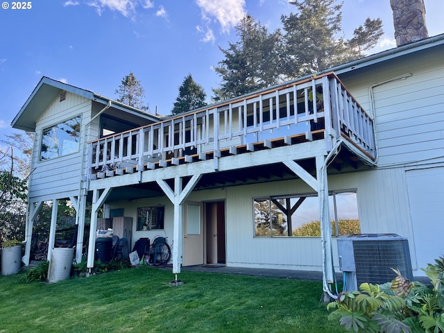rear view of house with a wooden deck, a chimney, central AC, and a lawn