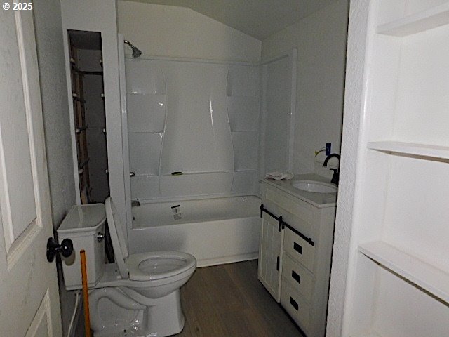 full bathroom with shower / washtub combination, vanity, wood-type flooring, and toilet