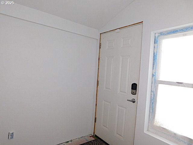 doorway featuring plenty of natural light and vaulted ceiling