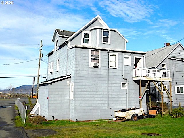 back of property with a yard and a deck