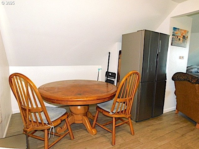 dining space with hardwood / wood-style floors and lofted ceiling