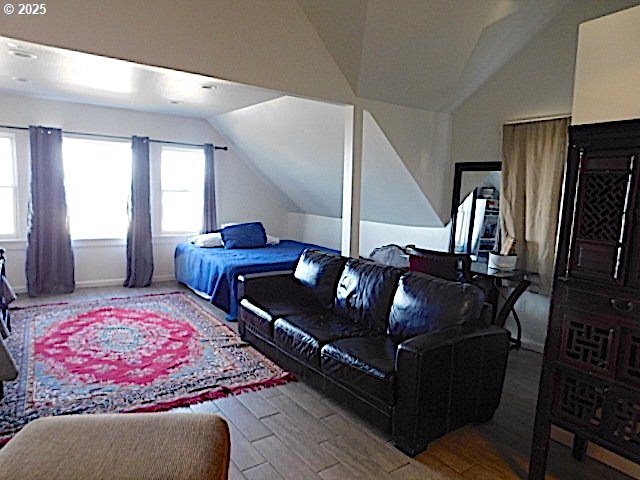 bedroom featuring wood-type flooring and vaulted ceiling