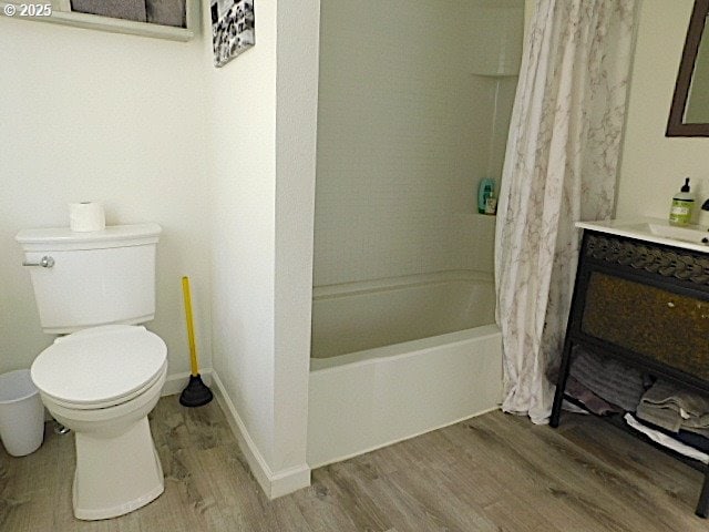 full bathroom featuring hardwood / wood-style floors, vanity, toilet, and shower / tub combo with curtain