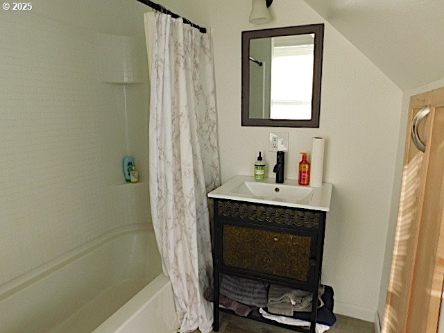 bathroom featuring lofted ceiling, vanity, and shower / bath combo