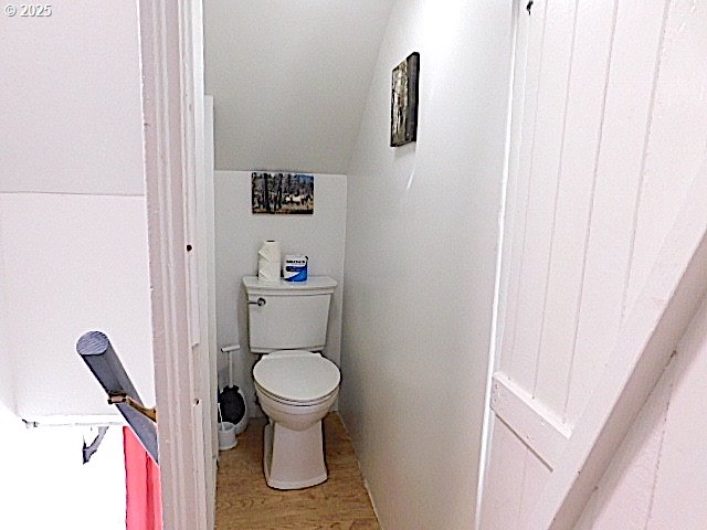 bathroom featuring toilet, lofted ceiling, and wood-type flooring