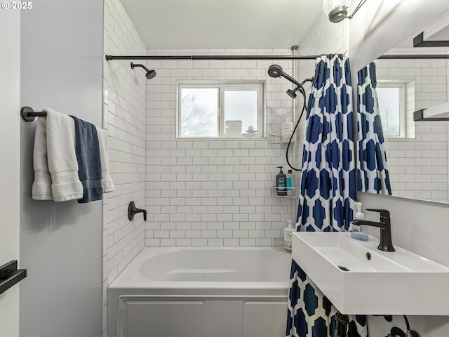 bathroom with shower / tub combo with curtain and a sink