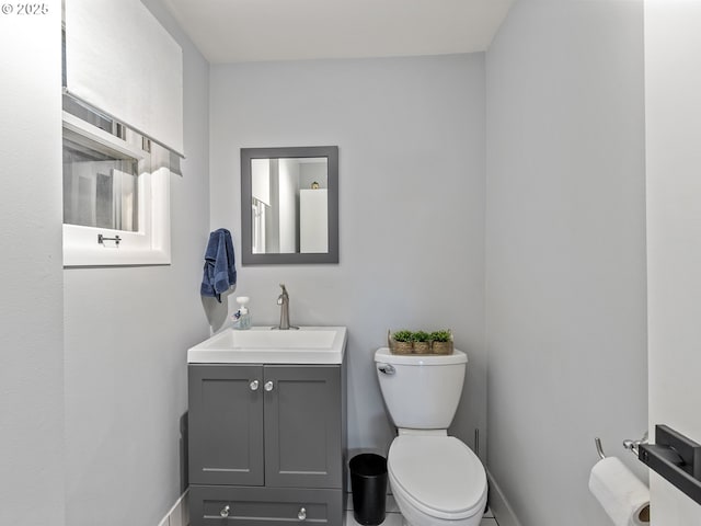 bathroom featuring baseboards, toilet, and vanity