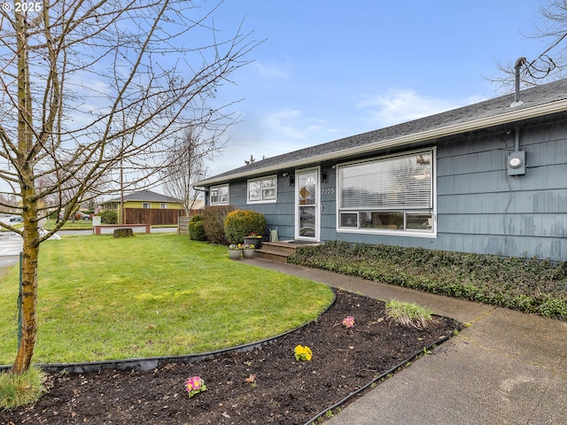 ranch-style house featuring a front lawn and fence