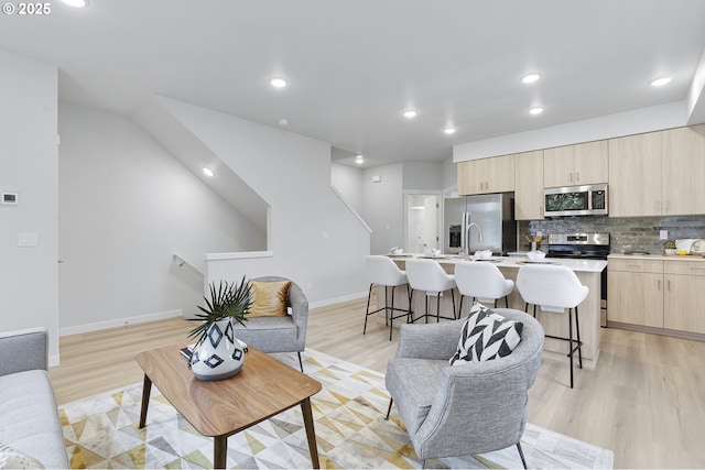 living area with light wood finished floors, recessed lighting, and baseboards