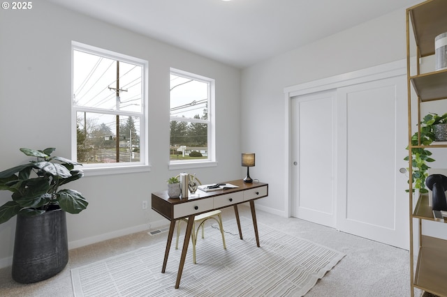 office featuring visible vents, baseboards, and light colored carpet