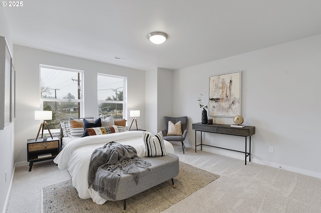 bedroom featuring visible vents, light carpet, and baseboards