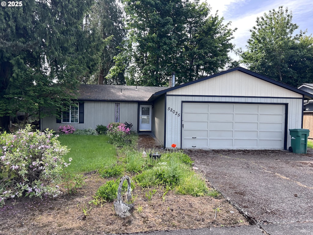 52035 SW 4th St, Scappoose, OR 97056 - ranch-style home featuring an attached garage, asphalt driveway, a front lawn, and roof with shingles