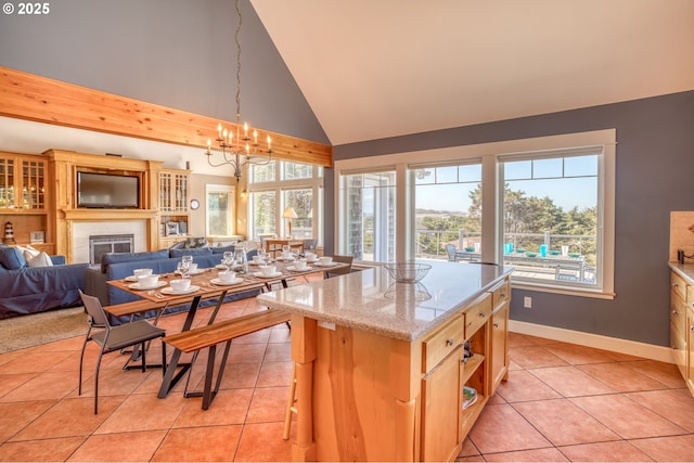 5020 NW Lee Ave, Lincoln City, OR 97367 - kitchen with light tile patterned flooring, a fireplace, high vaulted ceiling, open floor plan, and light stone countertops