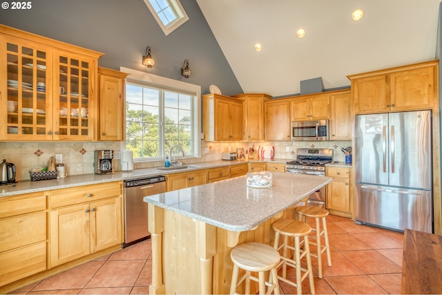 5020 NW Lee Ave, Lincoln City, OR 97367 - kitchen with appliances with stainless steel finishes, high vaulted ceiling, light tile patterned floors, a kitchen bar, and decorative backsplash