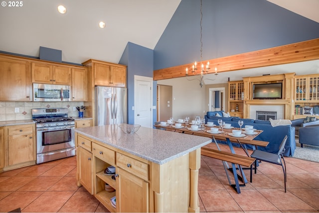 5020 NW Lee Ave, Lincoln City, OR 97367 - kitchen featuring stainless steel appliances, high vaulted ceiling, open floor plan, light tile patterned floors, and a chandelier