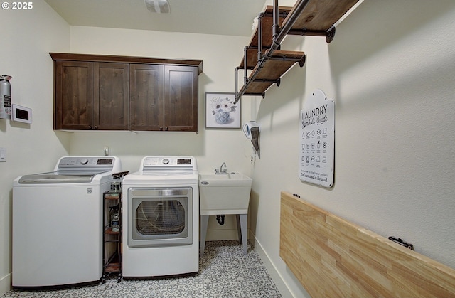 laundry room featuring baseboards, cabinet space, and washer and clothes dryer