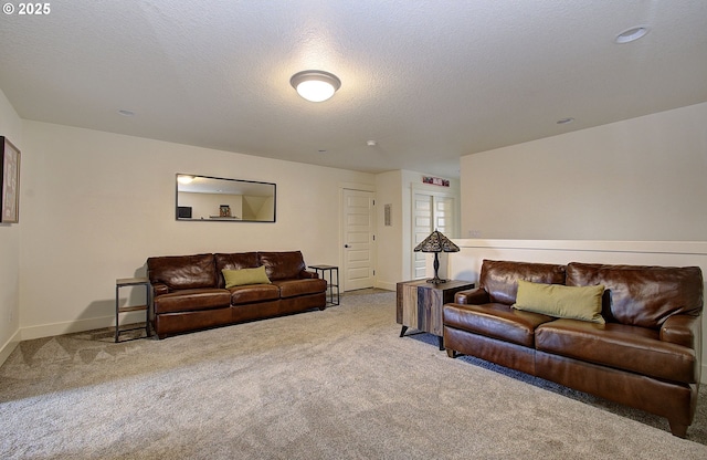 living area featuring baseboards, carpet, and a textured ceiling