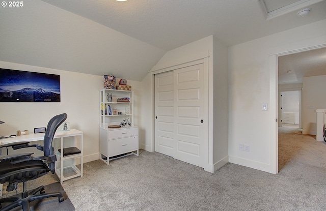 office featuring vaulted ceiling, baseboards, and light carpet