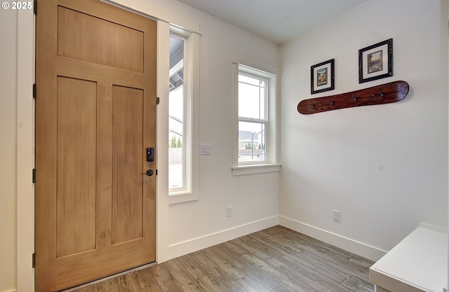 entryway with light wood-type flooring and baseboards