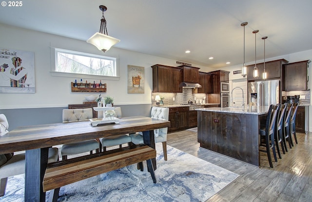 dining room with recessed lighting and light wood-style floors