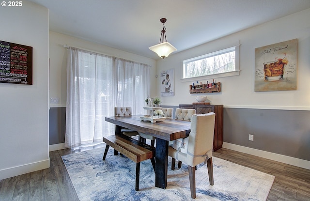 dining area with baseboards and wood finished floors