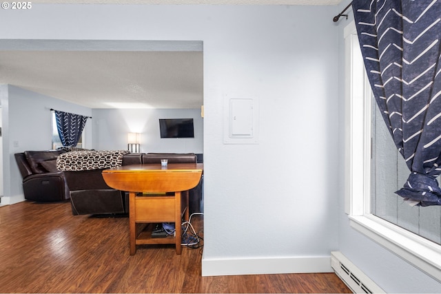 living room with a baseboard radiator, a textured ceiling, baseboards, and wood finished floors