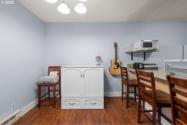 office with a baseboard heating unit, dark wood finished floors, a textured ceiling, and baseboards